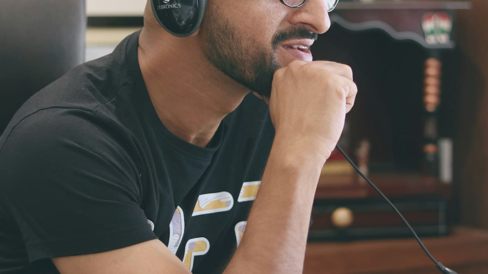 A caller wearing a headset with a microphone listens closely during a call