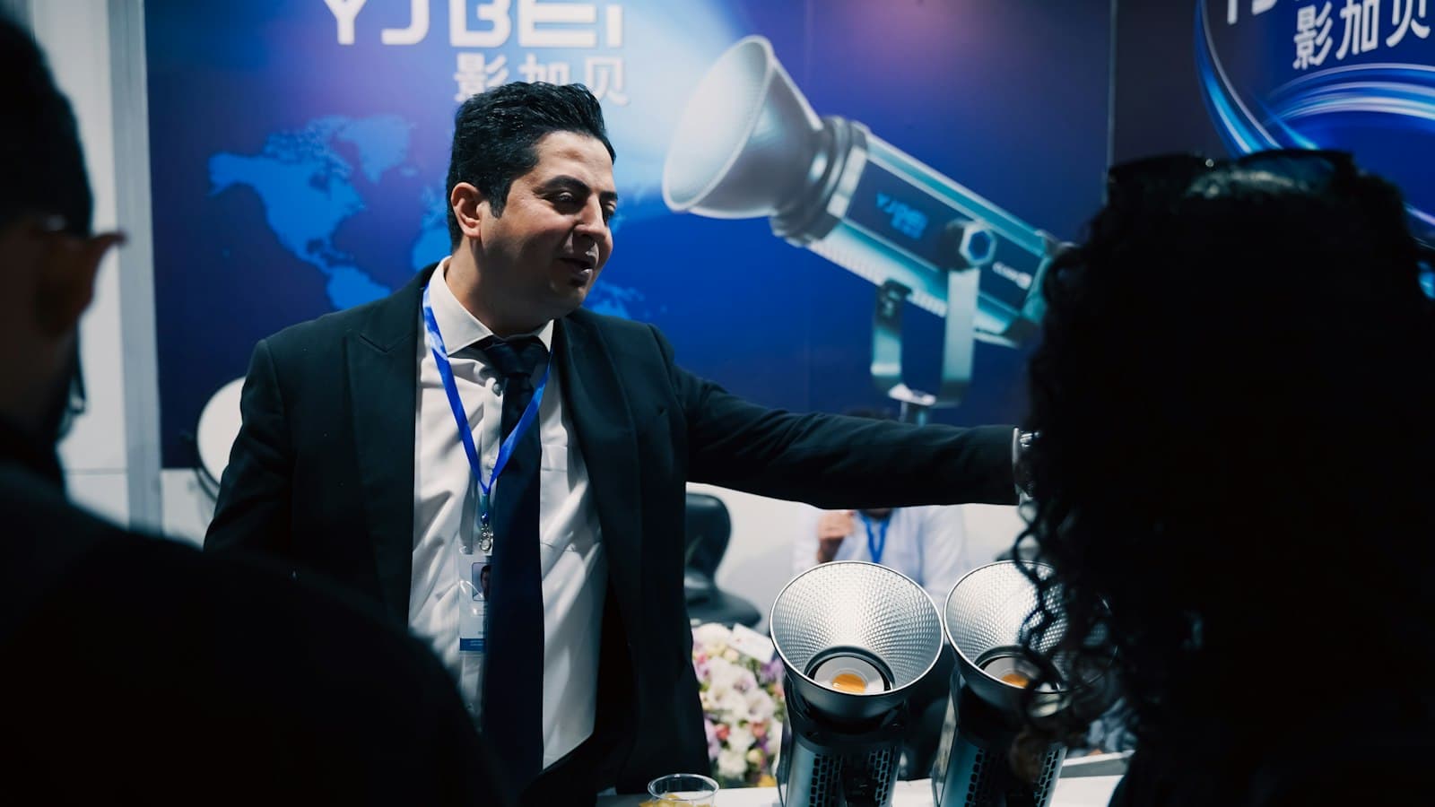 A salesperson at an exhibition stall talks visitors through the products on display