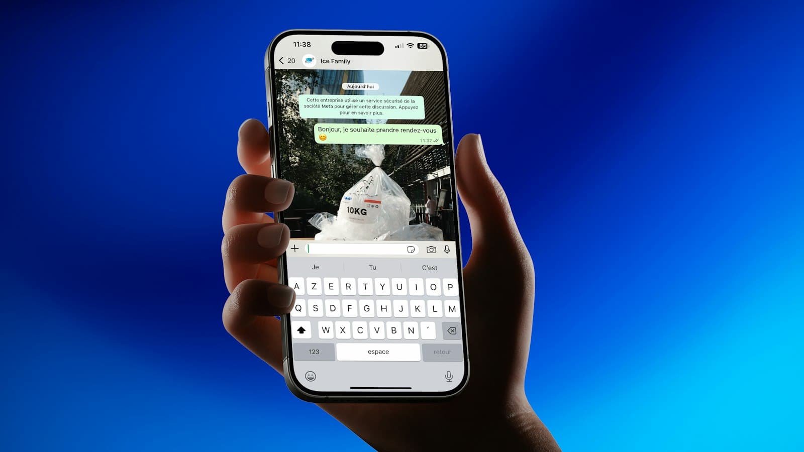 Hand holding a smartphone showing a WhatsApp chat
