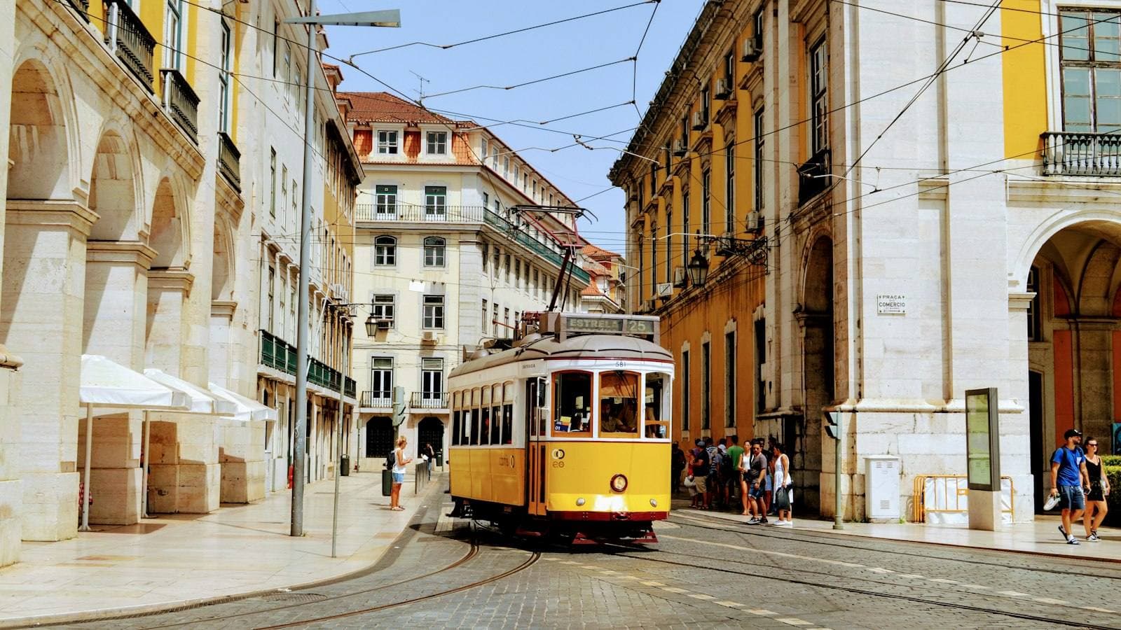 A yellow tram on Praça do Comércio in Lisbon