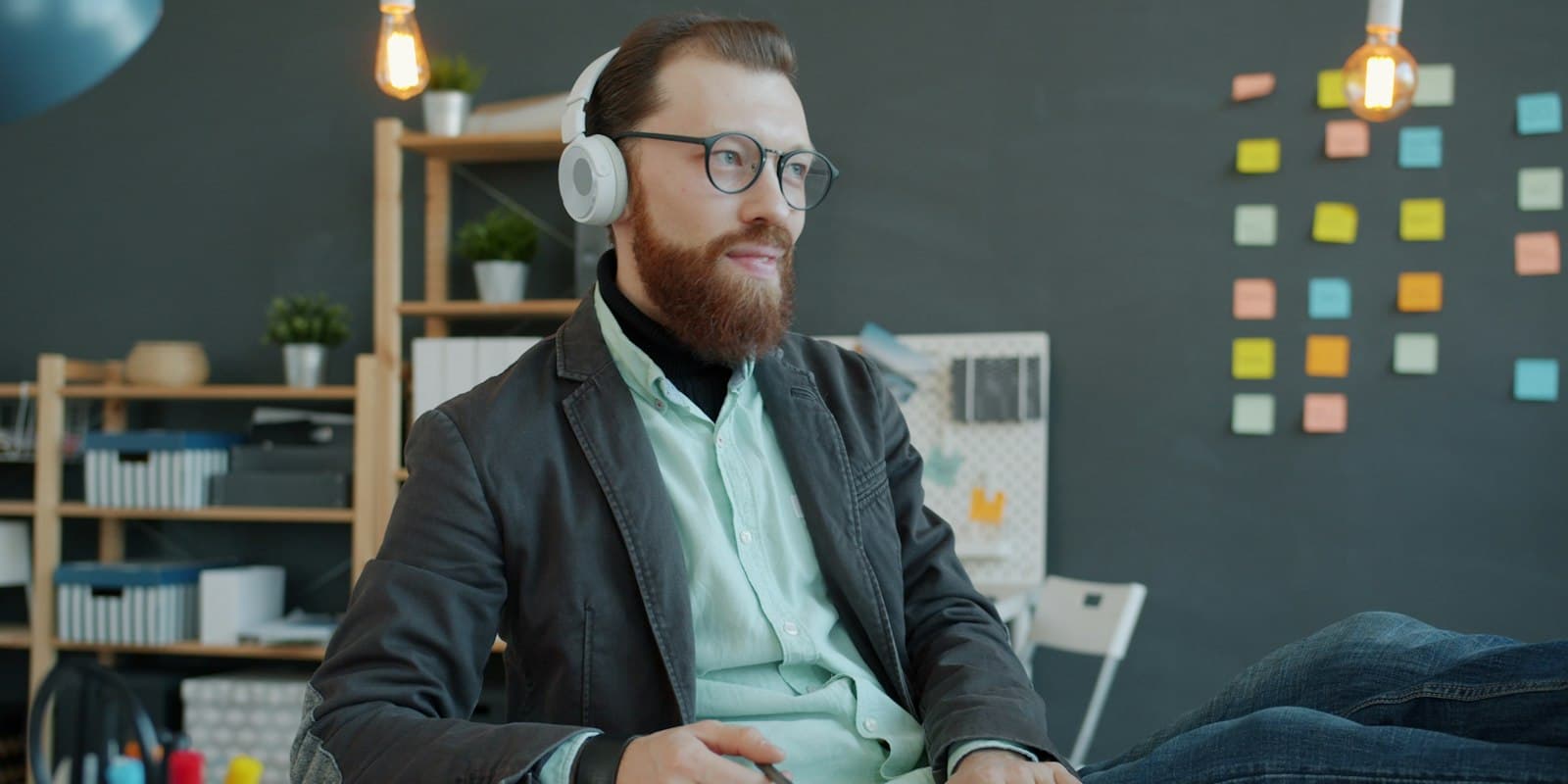 Team lead reviewing a recorded call with headphones at his desk
