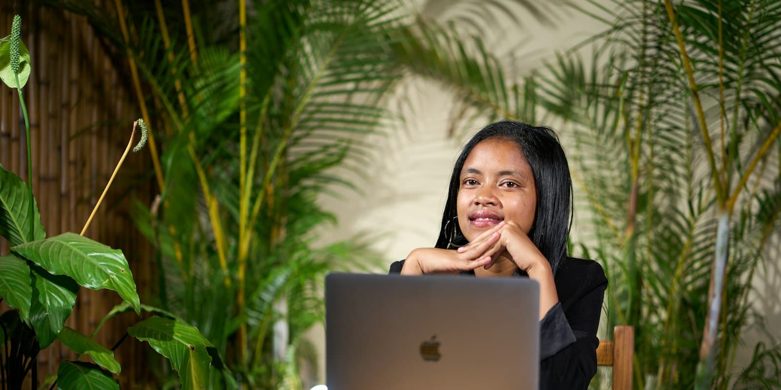 Professional working calmly on a laptop surrounded by plants