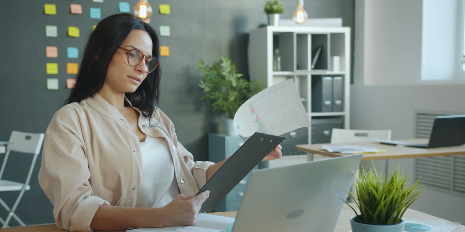 Sales manager reviewing a printed lead sheet at her desk