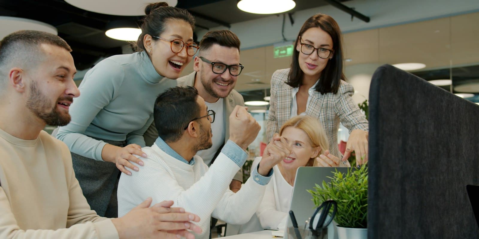A sales team celebrating together around a desk