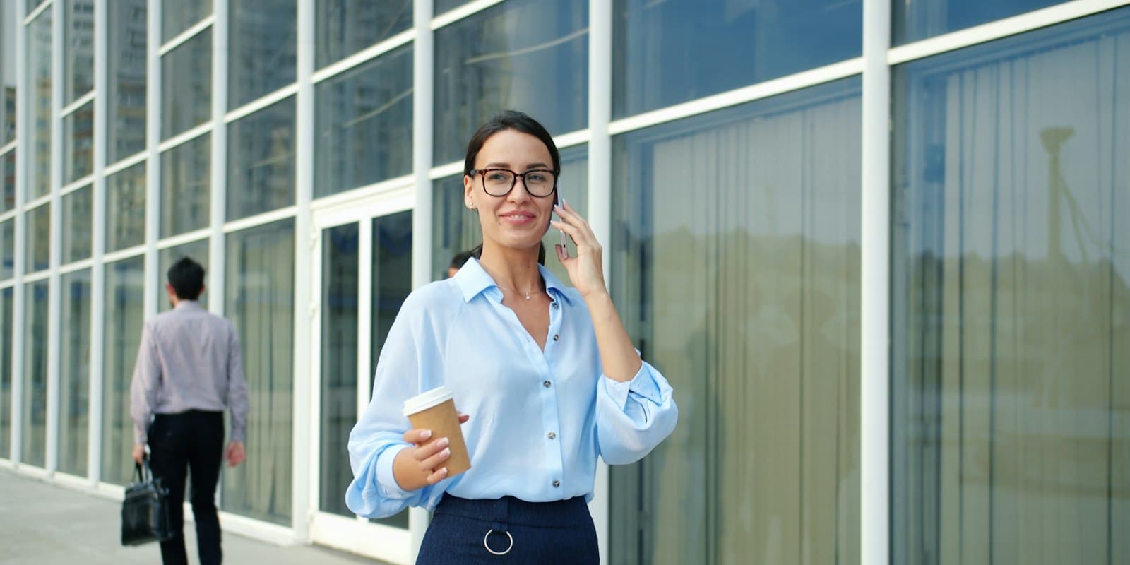 Professional on an iPhone call outside a modern office