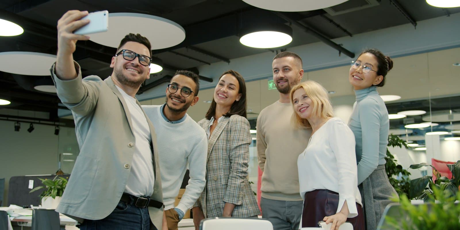 A multilingual team taking a selfie in the office