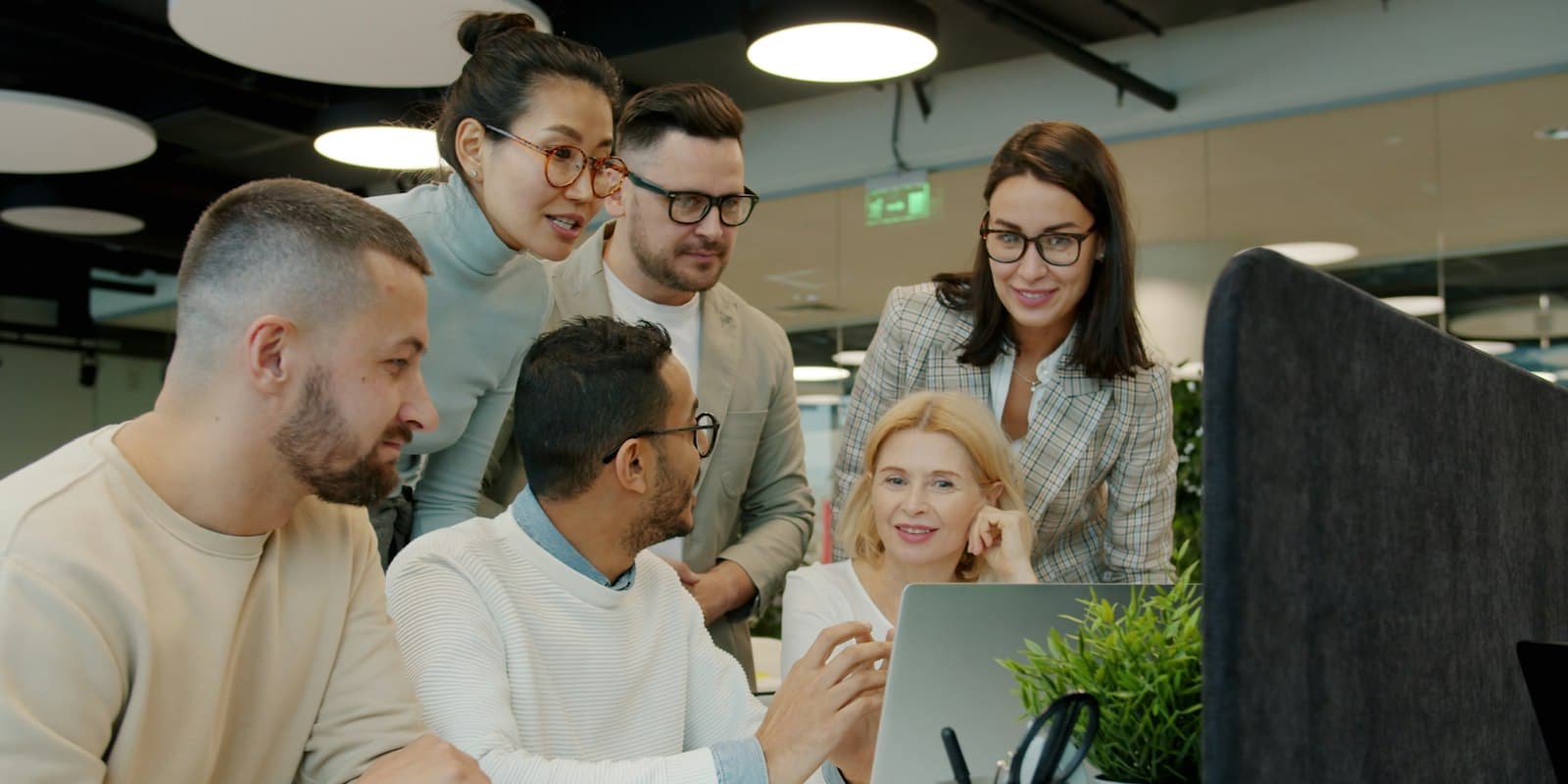 Team lead and agents looking at the live board on a laptop together
