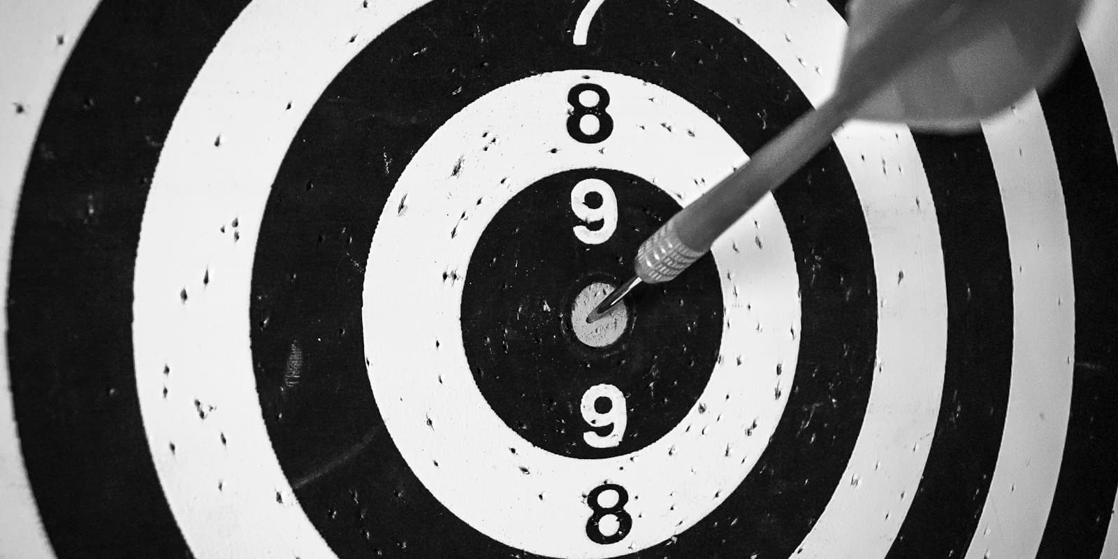 A dart in the centre of a black and white target