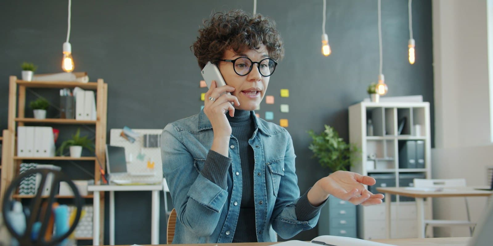 Sales agent on a call from her mobile in an open-plan office