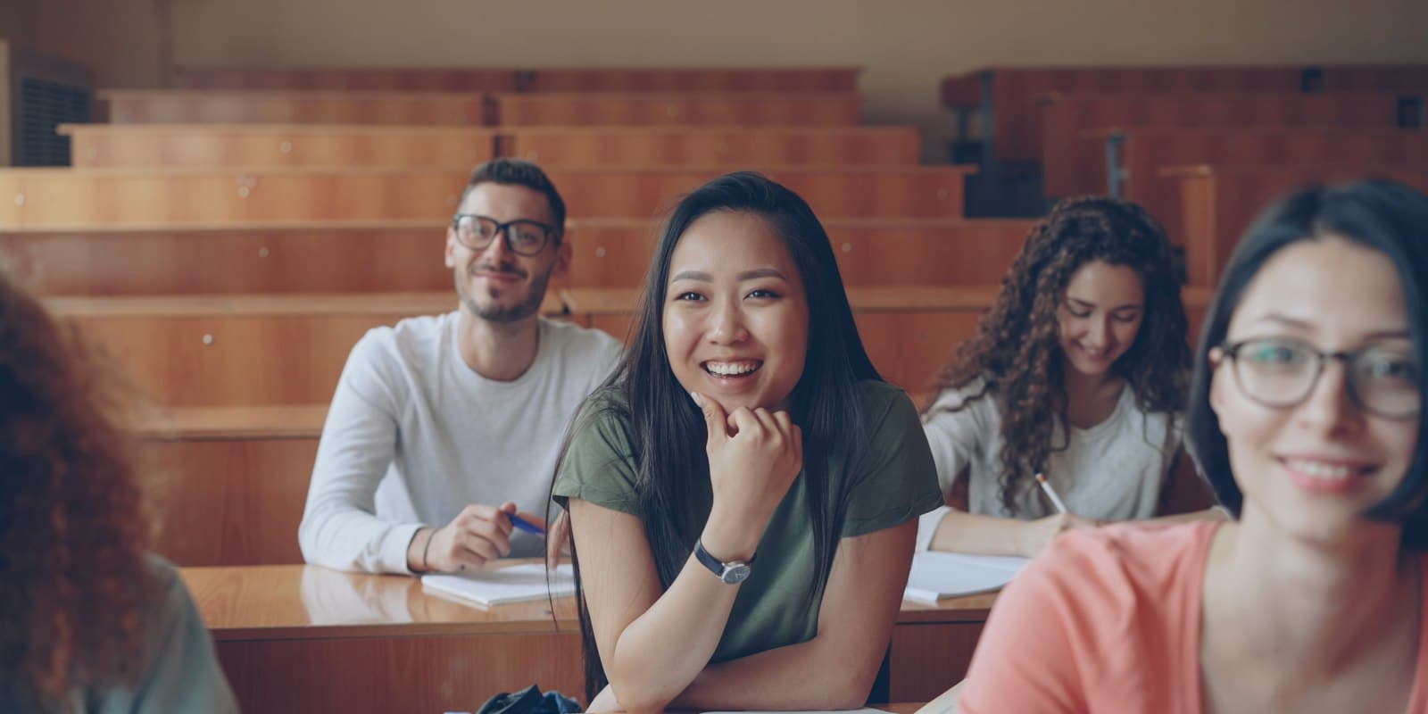 Smiling students sitting together in a university lecture hall
