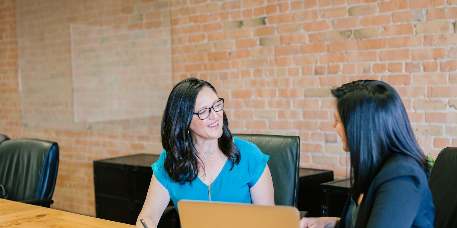 A loan advisor talking a client through her options across a desk