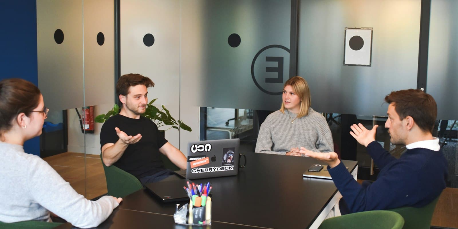 A small B2B team discussing a project around a meeting-room table