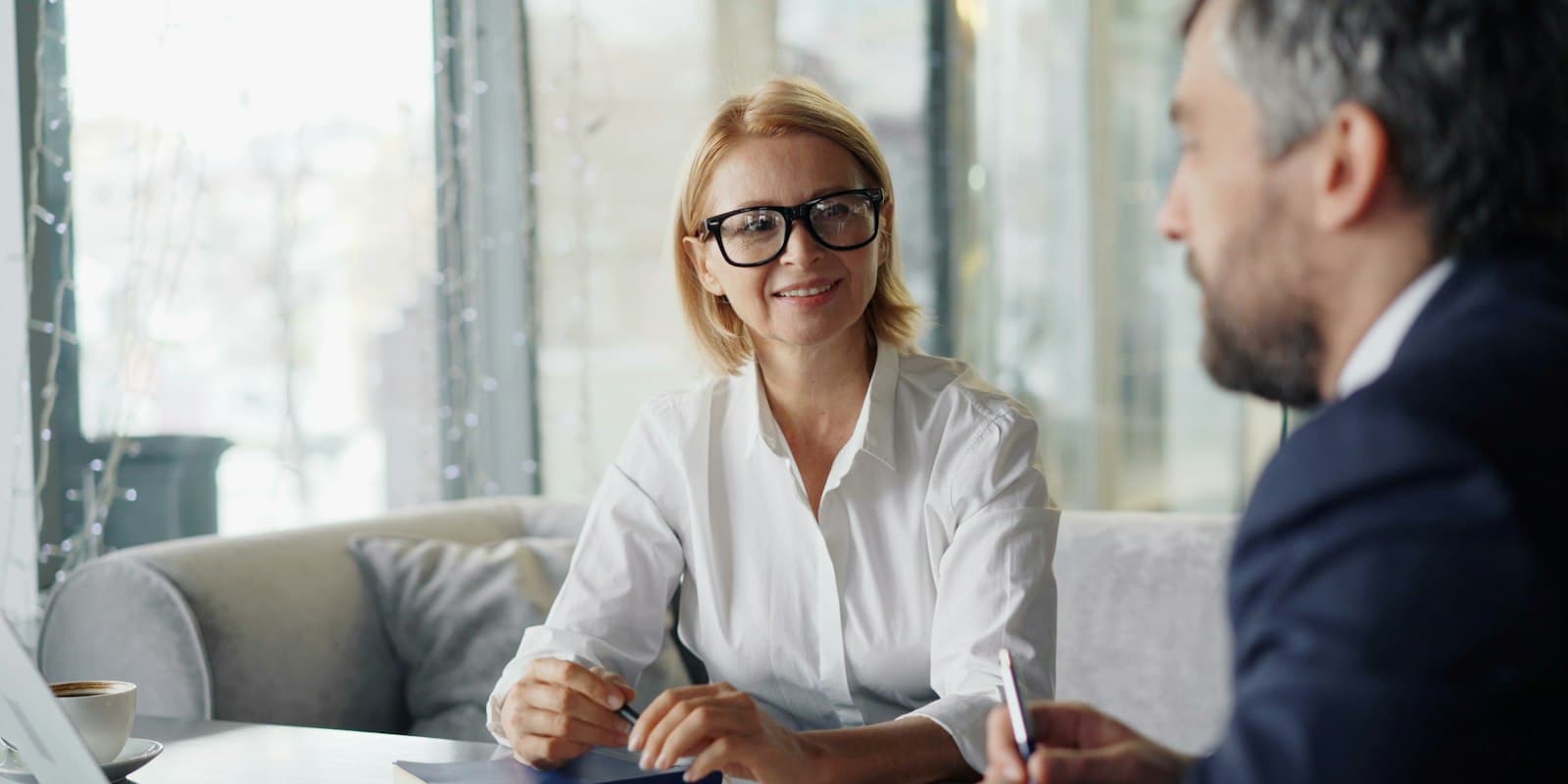 A loan advisor in glasses going through paperwork with a client