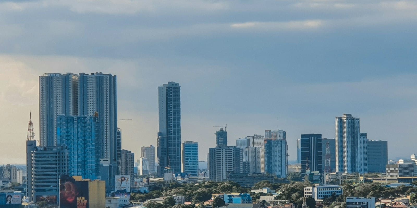High-rise towers in Quezon City, Metro Manila, under a cloudy sky
